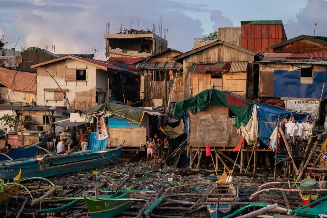 Many families living in poverty built their homes and communities near Manila Bay because it’s cheap and close to work. Image by Micah Castelo. Philippines, 2019. Many families living in poverty built their homes and communities, pictured here, near Manila Bay because it’s cheap and close to work. Image by Micah Castelo. Philippines, 2019.