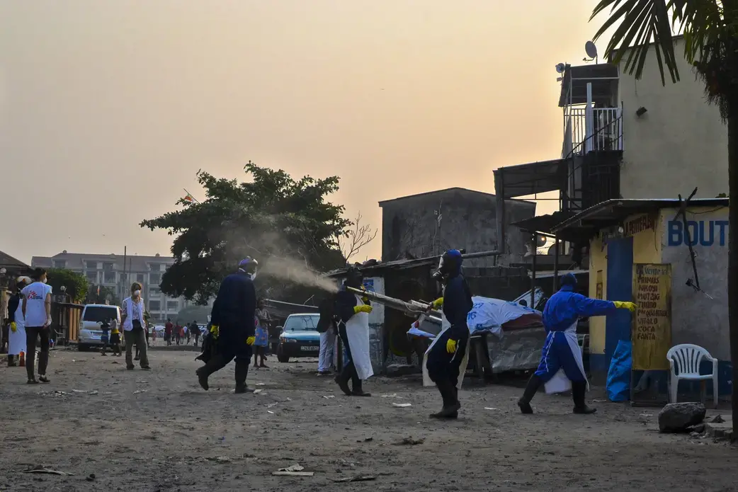 Vector control workers fumigate yellow fever breeding grounds in a neighborhood of Kinshasa. Image by Emily Baumgaertner. DRC, 2016. Media file: sciam1.jpg