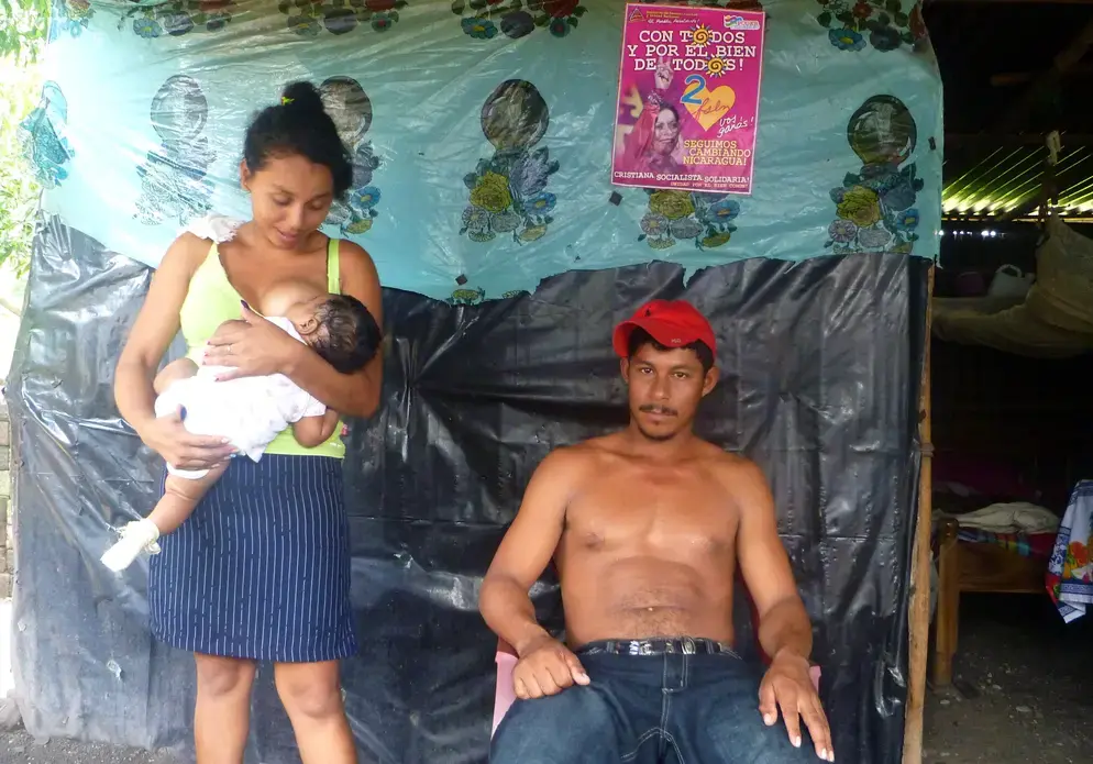 First Lady Rosario Murillo smiles down on a couple and their baby in Malacatoya, a fishing town in southern Nicaragua. Image by Eleanor Klibanoff. Nicaragua, 2013. Media file: p1020707.jpg