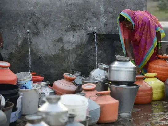 People in the Indian farming village of Dapegaon leave water jugs in line overnight and return at dawn to fill up before the daily supply of water runs out. The village relies on a single well, and shortages have worsened over the past several years as groundwater levels have declined. Image by Steve Elfers. India, 2015. Dapegon