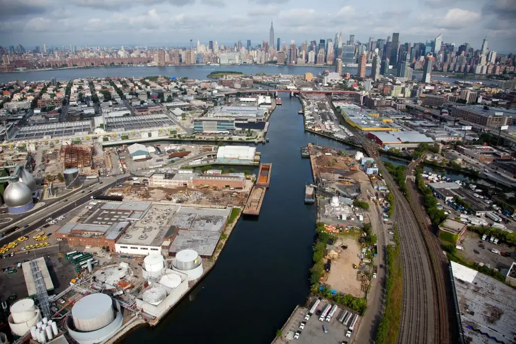 Newtown Creek, a 5.5 kilometer-long tributary of New York’s East River, is one of the most heavily industrialized and polluted sites in the United States. Water overflowed the armored banks of the waterway during Hurricane Sandy, spreading untreated sewage and toxic chemicals into city streets and basements. The Newtown Creek Wastewater Treatment Plant (the silver egg-shaped tanks on the far left), the largest of New York’s 14 sewage processing facilities, was responsible for the sewage—it released 550 million liters after becoming submerged. Image by Alex MacLean. United States, 2019. Newtown Creek, a 5.5 kilometer-long tributary of New York’s East River, is one of the most heavily industrialized and polluted sites in the United States. Water overflowed the armored banks of the waterway during Hurricane Sandy, spreading untreated sewage and toxic chemicals into city streets and basements. The Newtown Creek Wastewater Treatment Plant (the silver egg-shaped tanks on the far left), the largest of New York’s 14 sewage processing facilities, was responsible for the sewage—it released 550…