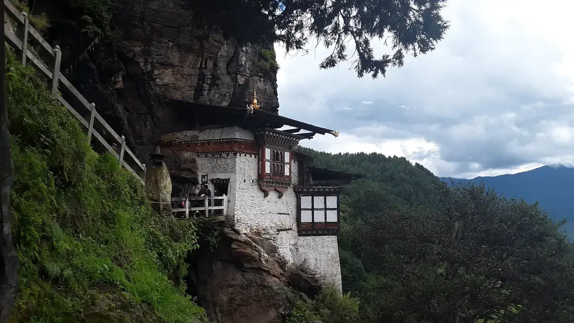A Buddhist temple hangs off a cliff in the Tang Valley in Bumthang, a district in central Bhutan. Image by Emma Johnson. Bhutan, 2019. A Buddhist temple hangs off a cliff in the Tang Valley in Bumthang, a district in central Bhutan. Image by Emma Johnson. Bhutan, 2019.
