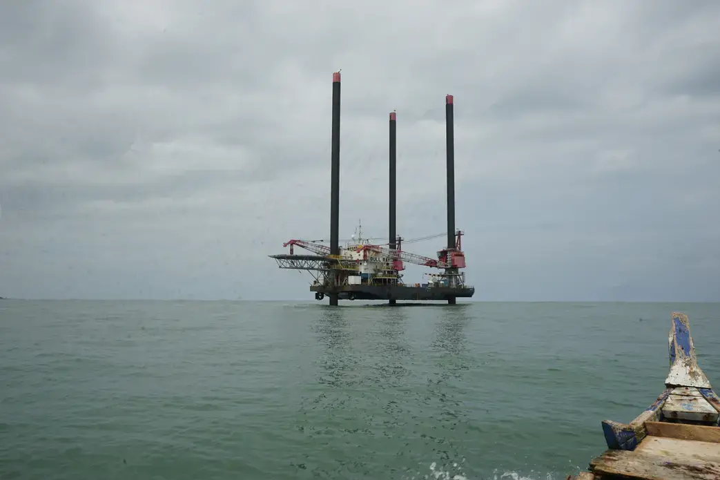 Oil production vessels like this now dot the west coast of Ghana. Employees will usually work for a few weeks on the vessel and then for a few weeks on the mainland. This photo was captured from a traditional fishing canoe, the main method of navigating the ocean for most of Ghana's fishermen. Image by John Soper. Ghana, 2015. Media file: c.well_from_view_of_fishing_boat_copy.jpg