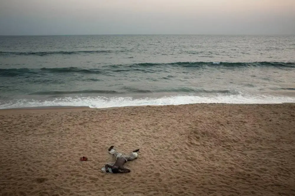 The ocean laps the shore at Trench Town, an informal settlement in Liberia’s capital Monrovia inhabited by mostly ex-combatants of Liberia’s civil wars. Image by Robin Hammond. Liberia, 2013. Media file: hammondliberiapulitzer04.jpg