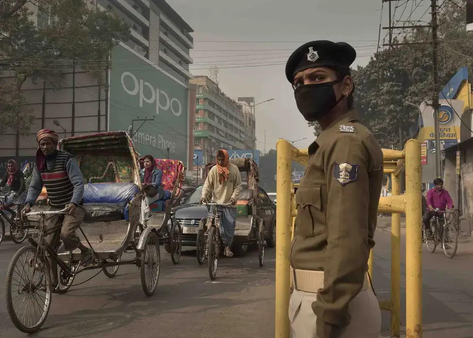Traffic policewoman Sandhya Bhartj directs traffic in central Patna. Her cloth mask does little to protect her from the smallest particulate pollution. Image by Larry C. Price. India, 2018. Traffic policewoman Sandhya Bhartj directs traffic in central Patna. Her cloth mask does little to protect her from the smallest particulate pollution. Image by Larry C. Price. India, 2018.
