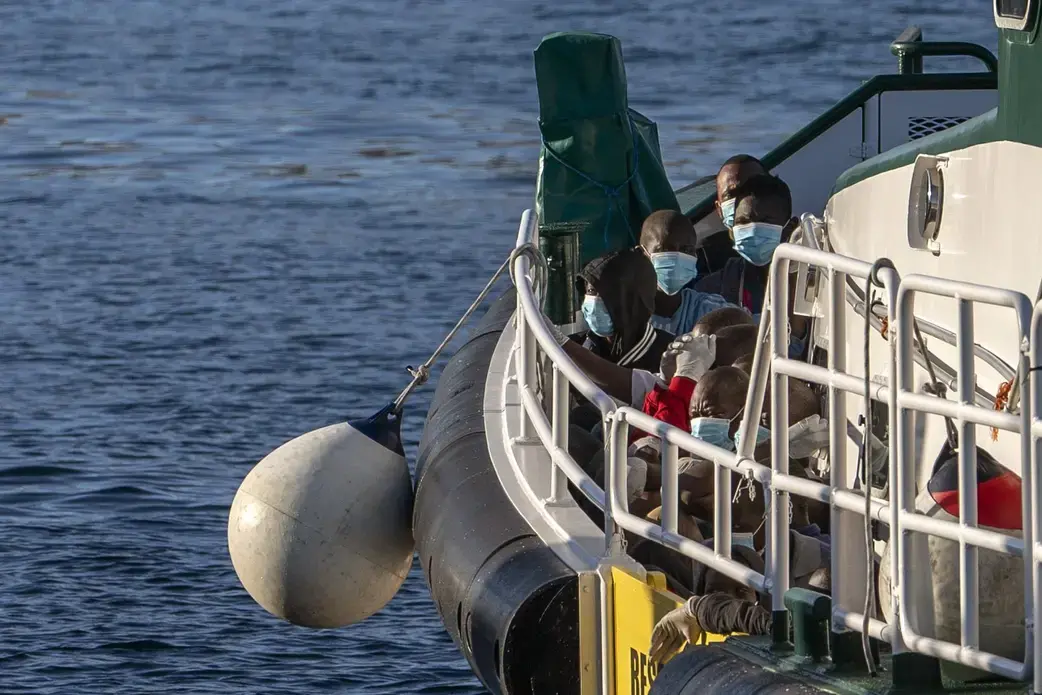 Migrants wearing face masks sit on the deck of a police rescue boat as they arrive at the Arguineguin port in Gran Canaria island, Spain, after being rescued in the Atlantic Ocean on Thursday, Aug. 20, 2020. Image by Emilio Morenatti/AP Photo. Spain, 2020. Media file: Migrants wearing face masks sit on the deck of a police rescue boat as they arrive at the Arguineguin port in Gran Canaria island, Spain, after being rescued in the Atlantic Ocean on Thursday, Aug. 20, 2020. Image by Emilio Morenatti/AP Photo. Spain,.jpeg