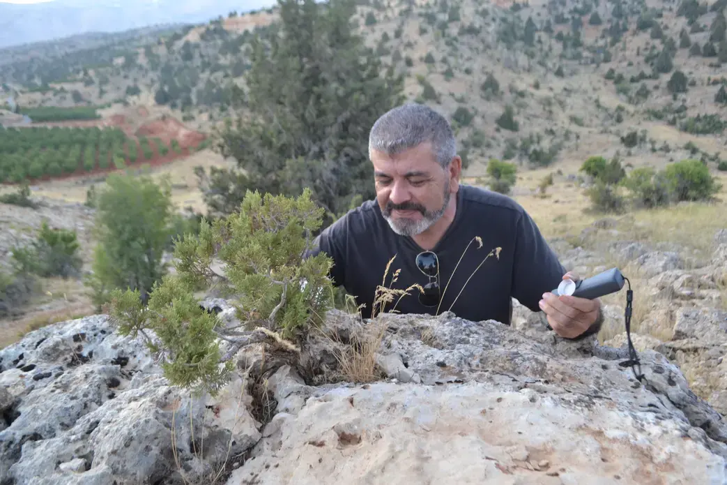 Antoine Geagea greets and waters a juniper tree growing on top of a boulder. Image by Catherine Cartier. Lebanon, 2019. Antoine Geagea greets and waters a juniper tree growing on top of a boulder. Image by Catherine Cartier. Lebanon, 2019.