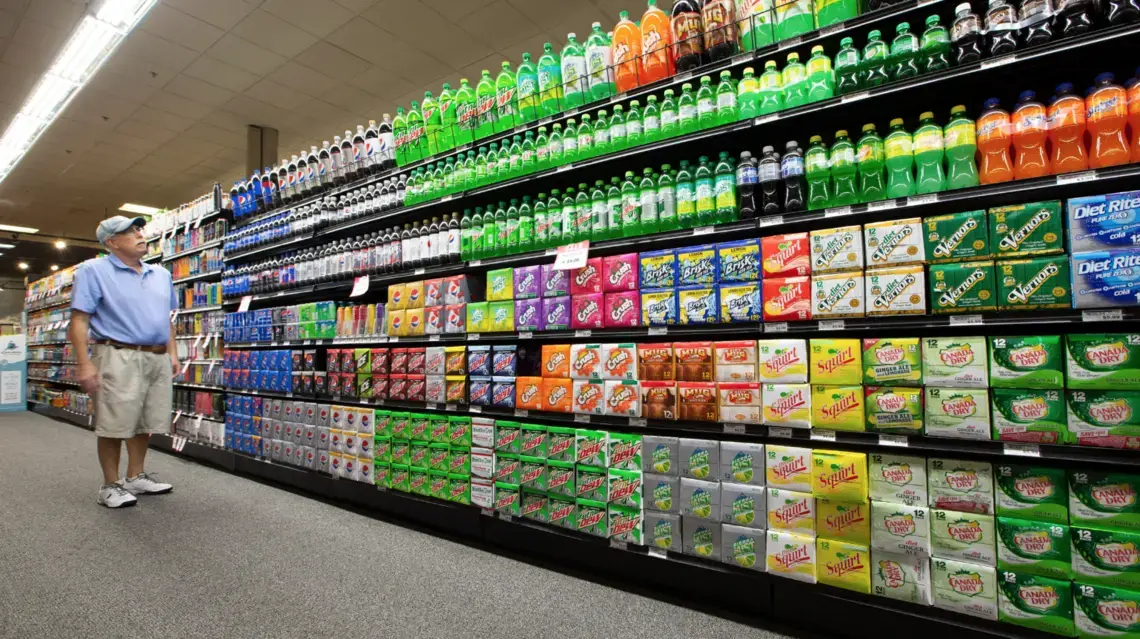 Steve Close of Fox Point shops in an aisle of sodas, energy drinks, drink mixers and more at Sendik's Food Market in Mequon. Image courtesy of Colin Boyle. United States, 2019. Steve Close of Fox Point shops in an aisle of sodas, energy drinks, drink mixers and more at Sendik's Food Market in Mequon. Image courtesy of Colin Boyle. United States, 2019.