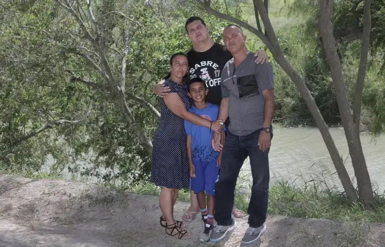 Clockwise from left to right: Mairen Barbara Almora, Abel Aguilar Almora (21 years old), Abel Aguilar Columbie, Sergio Almora (9 years old), pose for a photo by the Rio Grande on the Mexican side of the border. Image by Jose A. Iglesias. Mexico, 2019.