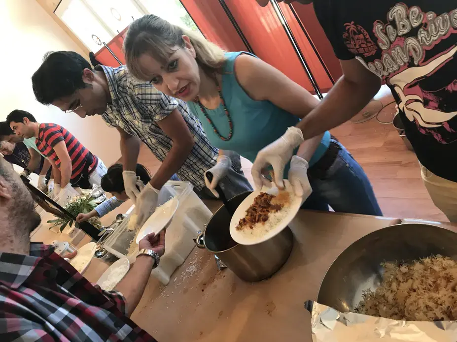 Members of a church in southern Berlin serve Iranian stew after Sunday service to a congregation of moslty Iranian and Afghan converts. Image by Alice Su. Germany, 2017.