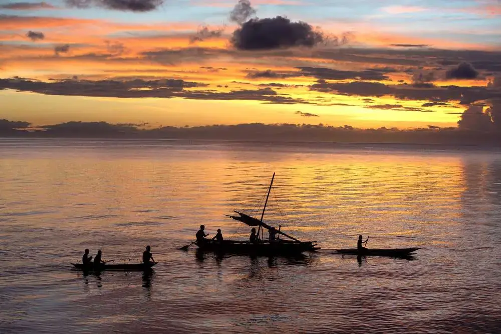 Fishermen gather at sunset in the South Pacific, off Normanby Island in Papua New Guinea. Nearly 1 billion people around the world get the bulk of their animal protein from fish. Image by Steve Ringman. Papua New Guinea, 2013. Media file: st_sea_change.jpg