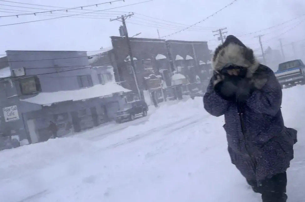 In this Feb. 23, 2019, photo, a woman shields her face from the wind during a snow storm as she walks on Front Street in Nome, Alaska. Image by Wong Maye-E. United States, 2019. In this Feb. 23, 2019, photo, a woman shields her face from the wind during a snow storm as she walks on Front Street in Nome, Alaska. Image by Wong Maye-E. United States, 2019.