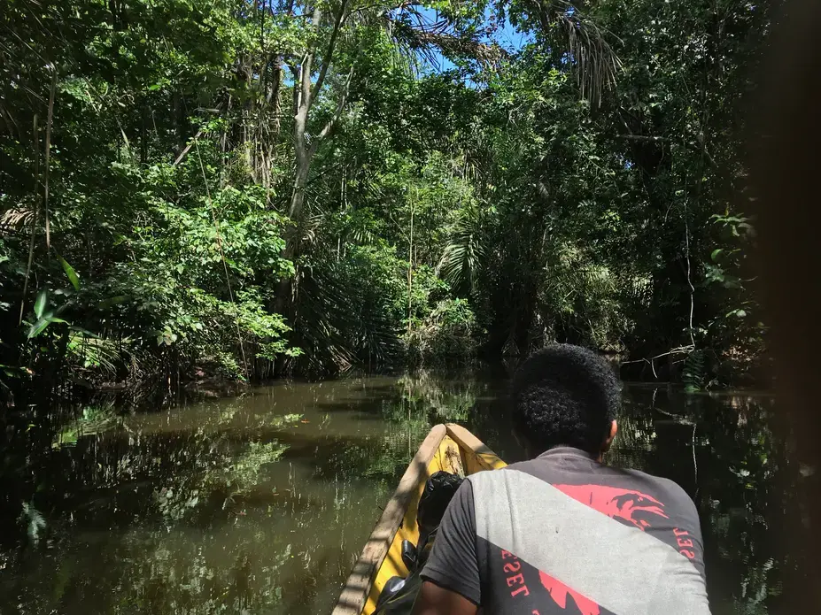 A smuggler guides travelers up the Cacarica River into the heart of the Darien Gap. Photo by Jason Motlagh.  2016.