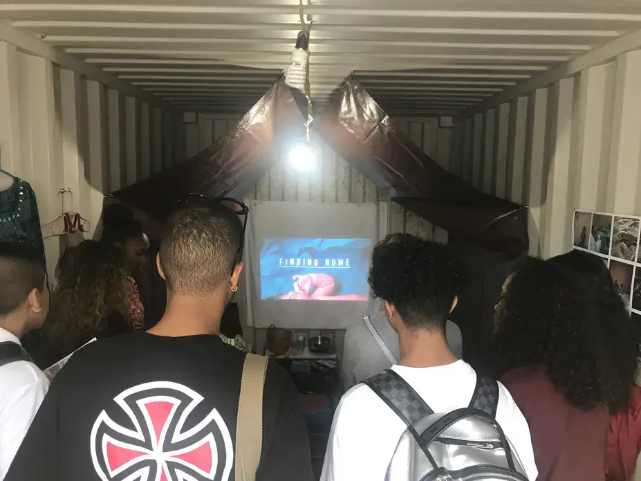 Students watch the trailer for "Finding Home" at Photoville 2017. As part of Photoville's Education Day, Pulitzer Center presented "Finding Home" to students across the four boroughs of New York City. Image by Jordan Roth. United States, 2017.