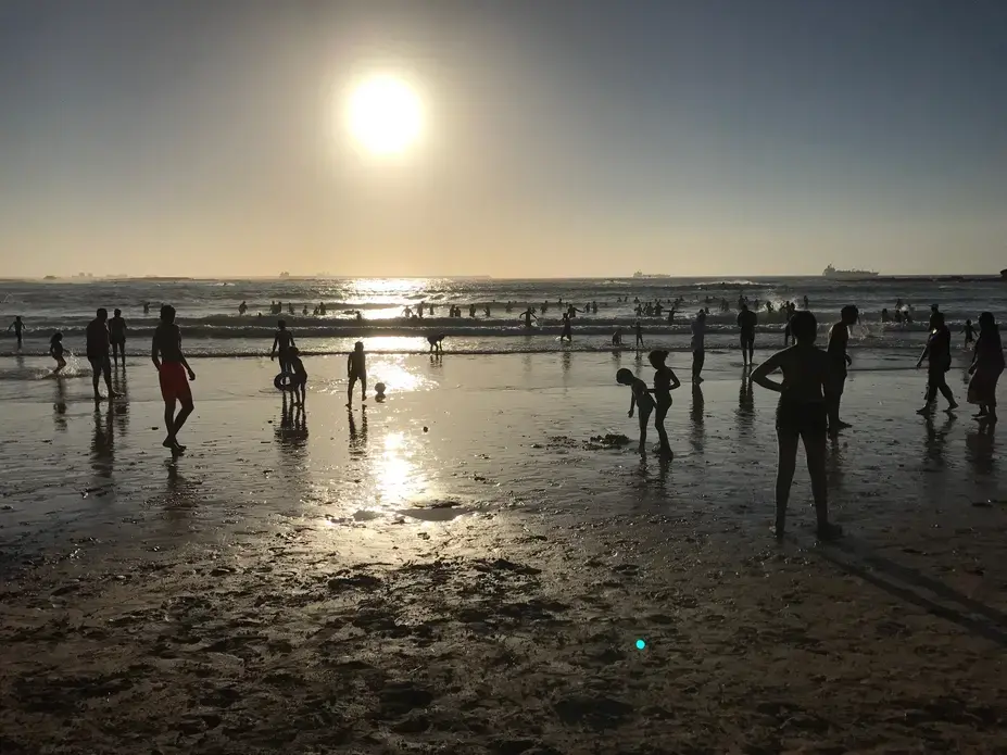 Visitors to the beach on the Atlantic Ocean in Mohammedia, Morocco, play in the surf as the sun sets. Morocco has emerged as a moderate leader admist the political and social turmoil of the rest of North African and the Middle East. Image by Jackie Spinner. Morocco, 2017.