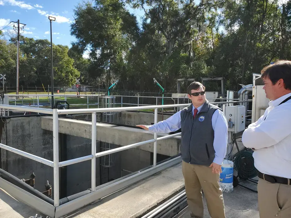 Brunswick-Glynn County Joint Water-Sewer Commission Executive Director Andrew Burroughs and Director of Engineering Todd Klein stand by the wet well at the Academy Creek Wastewater Treatment Plant. Its low walls mean water from a flood could infiltrate it. Image by Emily Jones/GPB News. United States, 2020.