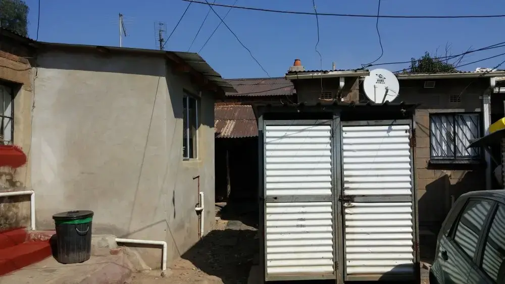 A property in Old Alex, the densest part of Alexandra township, where up to a dozen families will sometimes live in a backyard together. Rosaline Selepe, who has lived in the house on the left since 1980, says that though she would like to expand her property, she has no space to do so. Image by Christian Belanger. South Africa, 2016. A property in Old Alex, the densest part of Alexandra township