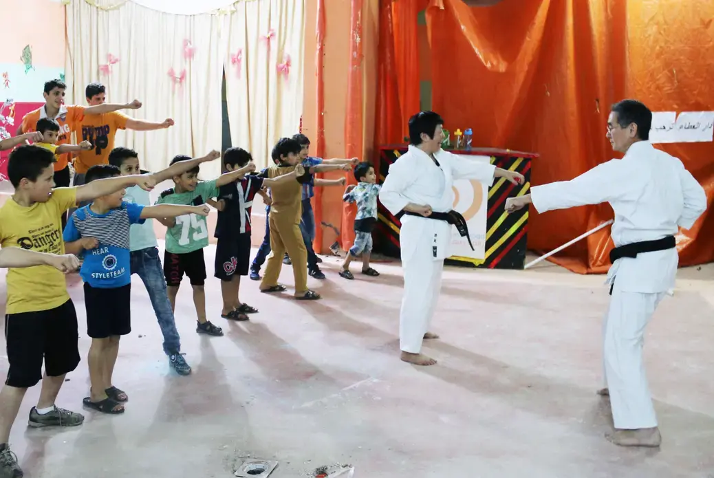 Local volunteers teach martial arts to young Syrian refugees at the Homs League Abroad in Amman. The center hopes such activities will bring positivity to the children's everyday lives. Image by Sawsan Morrar. Jordan, 2017. Local volunteers teach martial arts to young Syrian refugees at the Homs League Abroad in Amman. The center hopes such activities will bring positivity to the children's everyday lives. Image by Sawsan Morrar. Jordan, 2017.