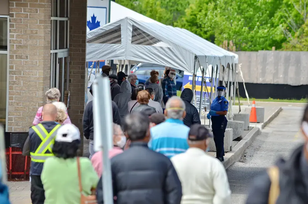 People wait in line for a COVID-19 test at a pop-up mobile Assessment Centre. Image by Bob Hilscher/Shutterstock. Canada, 2020. People wait in line for a COVID-19 test at a pop-up mobile Assessment Centre. Image by Bob Hilscher/Shutterstock. Canada, 2020.