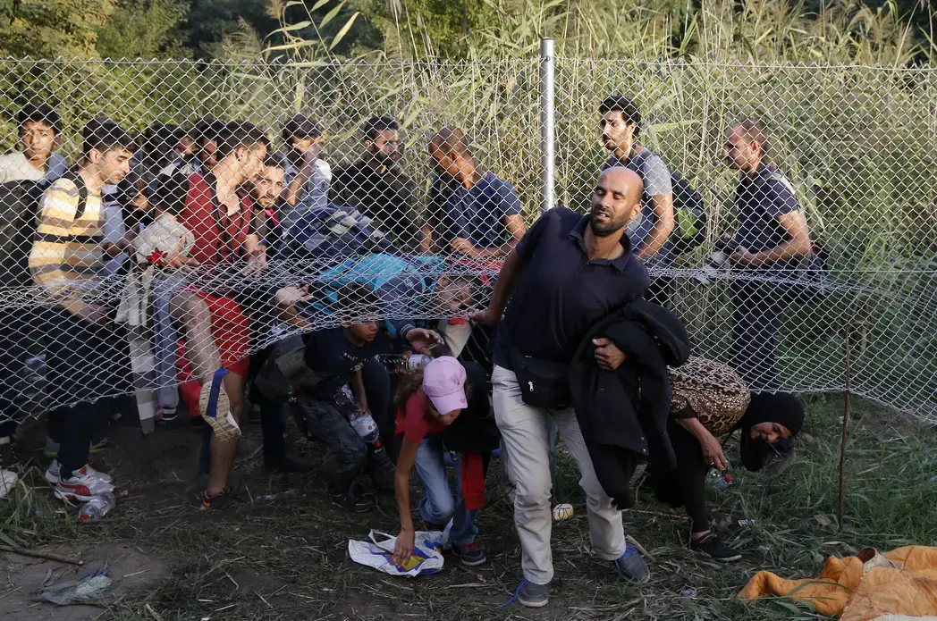 Migrants pass under a highway security fence as they try to find a new way to enter Hungary after Hungarian police sealed the border with Serbia near the village of Horgos, Serbia. Image courtesy of REUTERS/Marko Djurica. Hungary, 2015. Media file: refugees_hungary001.jpg