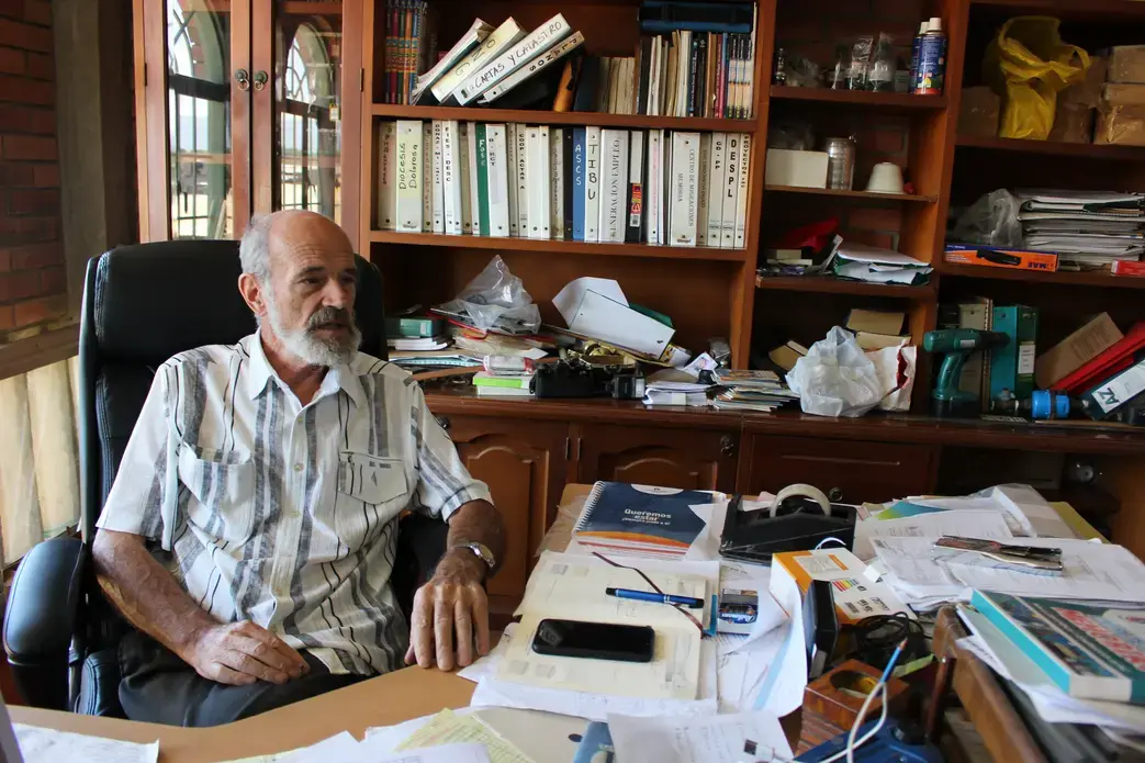 The Rev. Francesco Bortignon in his office explains the daily functions of Mision Scalabrini Cucuta. They provide housing, meals, and education to migrant families. Image by Mariana Rivas. Colombia, 2019.