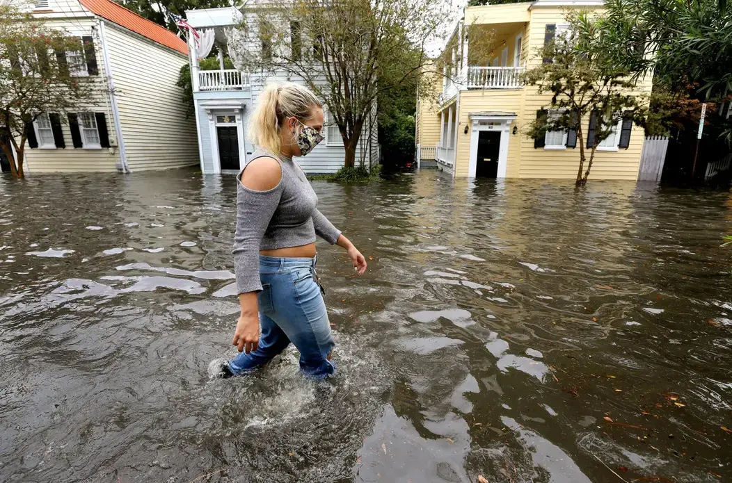Kirstin Janssen walks through the flooded Vanderhorst Street on Friday, Sept. 25, 2020, in Charleston. Image by Grace Beahm Alford/Post and Courier Staff. United States, 2020. Kirstin Janssen walks through the flooded Vanderhorst Street on Friday, Sept. 25, 2020, in Charleston. Image by Grace Beahm Alford/Post and Courier Staff. United States, 2020.