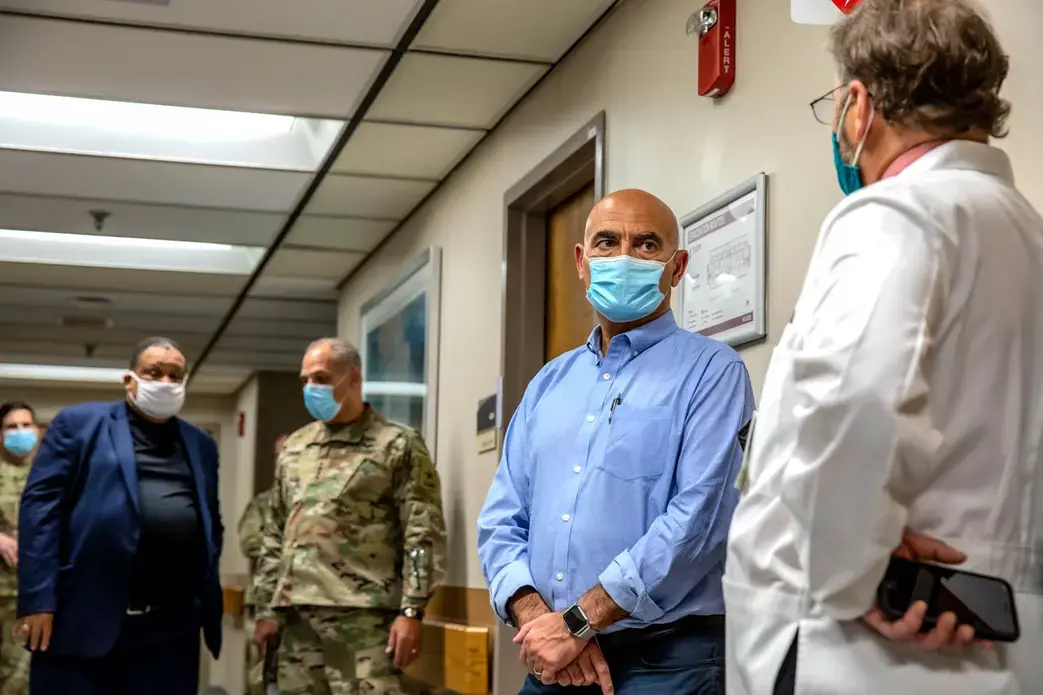 Operation Warp Speed leaders Moncef Slaoui (second from right) and Gen. Gustave Perna (second from left) speak with Cincinnati physicians Carl Fichtenbaum (far right) and O’dell Moreno Owens (far left) during a visit to one of the sites for the efficacy trial of Moderna’s COVID-19 vaccine candidate. Image courtesy of University of Cincinnati Health. United States, 2020. Operation Warp Speed leaders Moncef Slaoui (second from right) and Gen. Gustave Perna (second from left) speak with Cincinnati physicians Carl Fichtenbaum (far right) and O’dell Moreno Owens (far left) during a visit to one of the sites for the efficacy trial of Moderna’s COVID-19 vaccine candidate. Image courtesy of University of Cincinnati Health. United States, 2020.