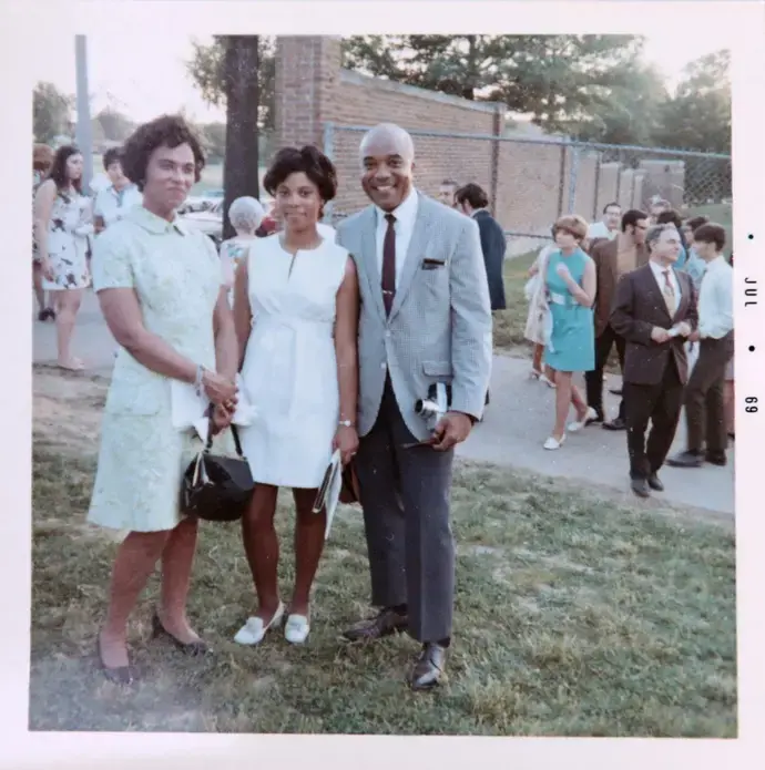 Judy Gladney, center, in a photograph with her parents, Clarice, left, and Dr. John Gladney at her University City High School graduation in 1969. Image courtesy of Judy Gladney. United States, 1969. Judy Gladney, center, in a photograph with her parents, Clarice, left, and Dr. John Gladney at her University City High School graduation in 1969. Image courtesy of Judy Gladney. United States, 1969.