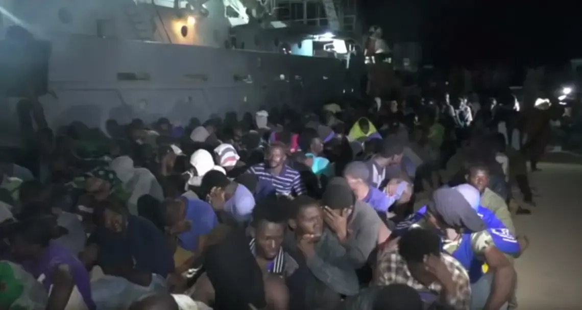 Migrants sit in a shipyard. Port city Sabratha used to be the migrant capital of Libya. Image courtesy of PBS NewsHour. Libya, 2018.