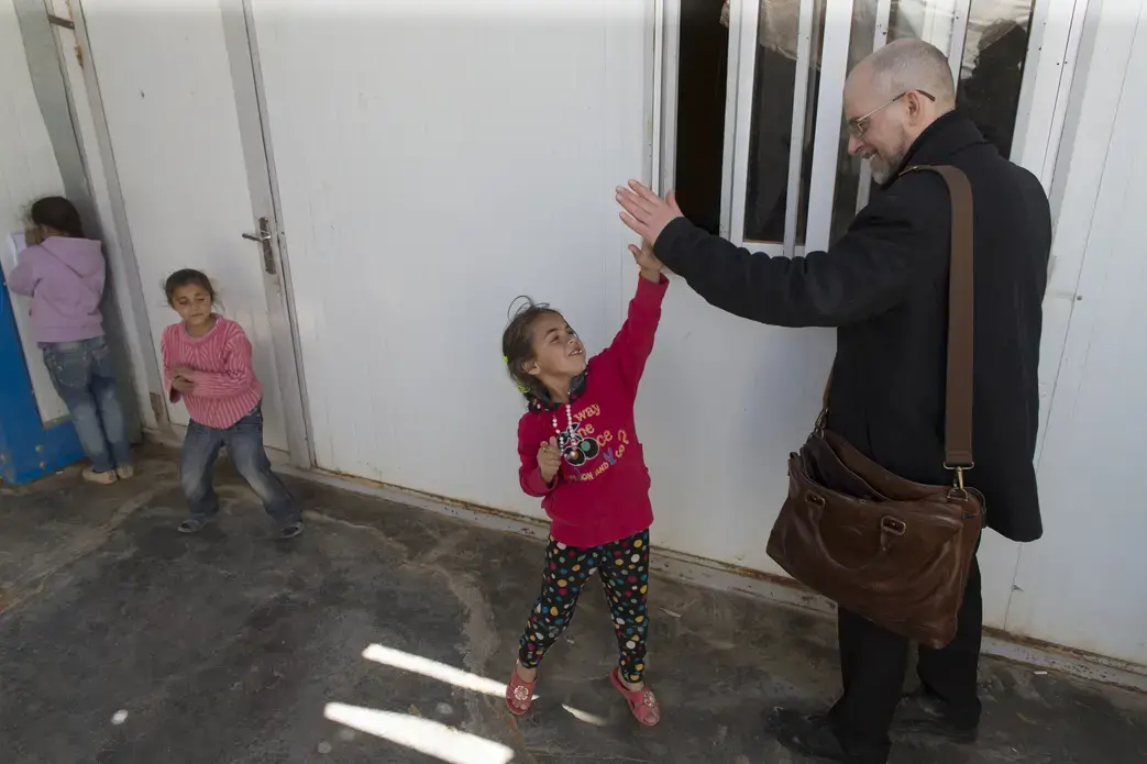 Milwaukee Journal Sentinel reporter Mark Johnson greets Syrian refugee children in the Zaatari refugee camp about 90 minutes north of Amman, Jordan.