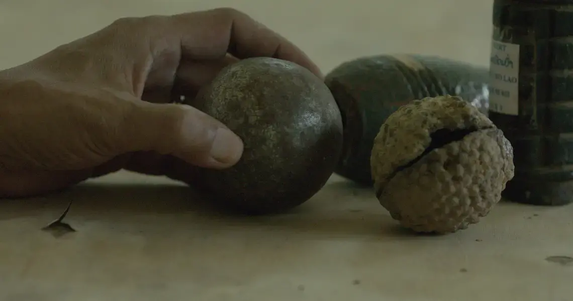 The UXO Lao Province Coordinator explains how similar petanque balls and cluster bombs are. The UXO Lao Province coordinator explains how similar petanque balls and cluster bombs are. Image by Erin McGoff. Laos, 2017.