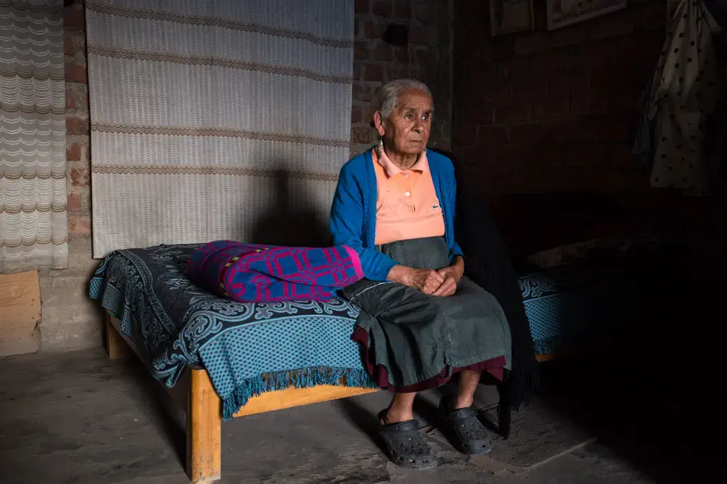 Luz Elena Avanto Urvina, 76, stares longingly at the outside world from her home where she lives alone. She stopped working more than a year ago due to worsening health conditions, yet has been unable to obtain appropriate care and treatment. She now relies on meager support from relatives and neighbors to survive. Image by Michelle Ferng. Peru, 2014. Media file: img_3076.jpg