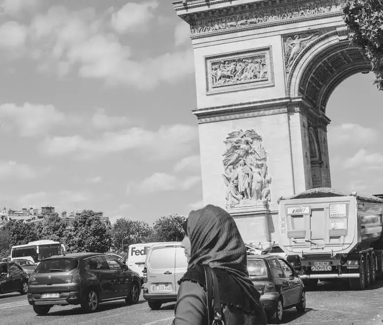 A woman wearing a hijab passes Paris' Arc de Triomphe. Hijabs have become one of the most contested aspects of the French ban on conspicuous religious symbols in public schools. Image by Charlotte Bellomy. France, 2015. Media file: hijabs_in_paris.jpg