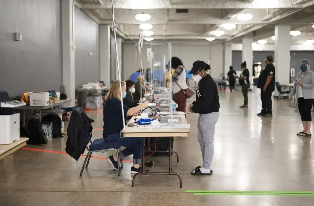 Polls open at the Lake Charles Civic Center on the first day of early voting with short wait times and clear social distancing measures following the “perfect storm, storm, storm” of disasters—a pandemic followed by back-to-back hurricanes. Image by Katie Sikora. United States, 2020.