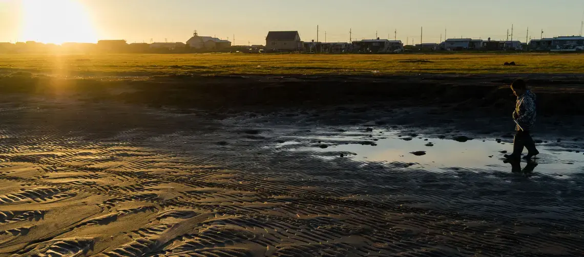 Brent Iyatunguk walks on the inland beach of the town of Shishmaref. Image courtesy of Nick Mott. United States, 2018. Brent Iyatunguk walks on the inland beach of the town of Shishmaref. Image courtesy of Nick Mott. United States, 2018.