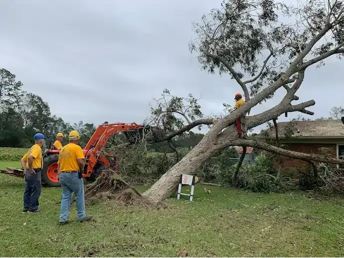 A volunteer disaster relief team with the Florida Baptist Convention removes a downed tree from a home in Silverhill, Ala., on Sept. 22, following Hurricane Sally. Image by Bob Smietana / Religion News Service. United States, 2020. A volunteer disaster relief team with the Florida Baptist Convention removes a downed tree from a home in Silverhill, Ala., on Sept. 22, following Hurricane Sally. Image by Bob Smietana / Religion News Service. United States, 2020.