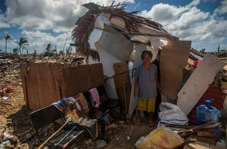 Super Typhoon Haiyan. A woman stands outside her makeshift shack in the storm’s aftermath. We “must integrate questions of justice in debates on the environment, so as to hear the cry of the earth and the cry of the poor,” wrote Pope Francis in his encyclical. Image by Mass Communication Specialist Seaman Liam Kennedy courtesy of the U.S. Navy. Philippines, 2013. Media file: bishops_photo.jpg