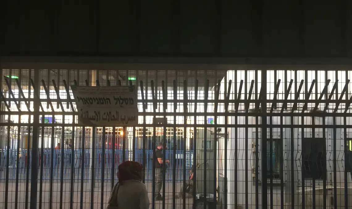 Israeli private security guards chat with Israel Defence Force (IDF) soldiers behind the bars at Qalandia checkpoint. Image by Matt Kennard. West Bank, 2016. Israeli private security guards chat with Israel Defence Force (IDF) soldiers behind the bars at Qalandia checkpoint. Image by Matt Kennard. West Bank, 2016.