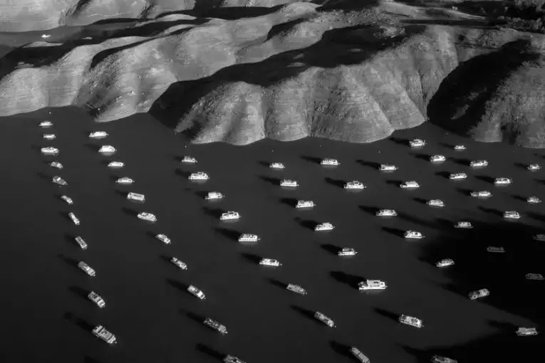 House boats appear next to the shoreline of Bidwell Canyon on Lake Oroville in Northern California on November 25, 2014. Lake Oroville is California's second largest reservoir, and is currently 70% empty as a result of the state's severe drought. Image by Tomas van Houtryve. United States, 2014.