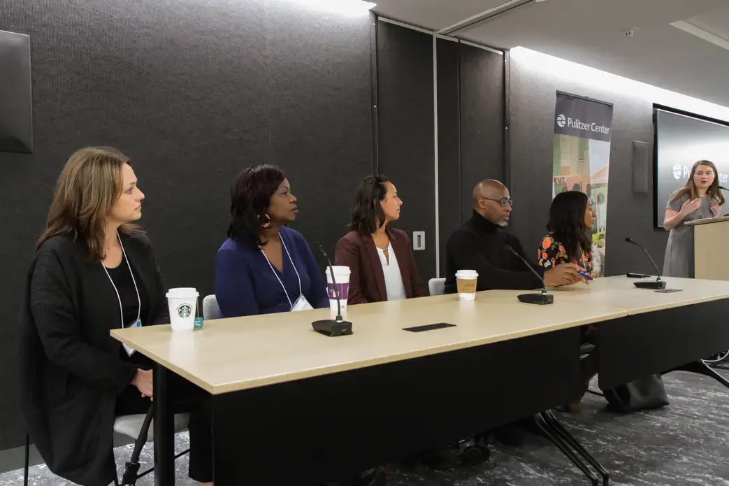 Pulitzer Center outreach coordinator Holly Piepenburg introduces the five panelists. From left to right: Time for Kids executive editor Jaime Joyce; Miami Herald correspondent Jacqueline Charles; digital video producer for National Geographic Gabrielle Ewing; senior investigative reporter for WGBH Phillip Martin; and multimedia reporter Melissa Noel. Image by Libby Moeller. United States, 2019. Pulitzer Center outreach coordinator Holly Piepenburg introduces the five panelists. From left to right: Time for Kids executive editor Jaime Joyce; Miami Herald correspondent Jacqueline Charles; digital video producer for National Geographic Gabrielle Ewing; senior investigative reporter for WGBH Phillip Martin; and multimedia reporter Melissa Noel. Image by Libby Moeller. United States, 2019.