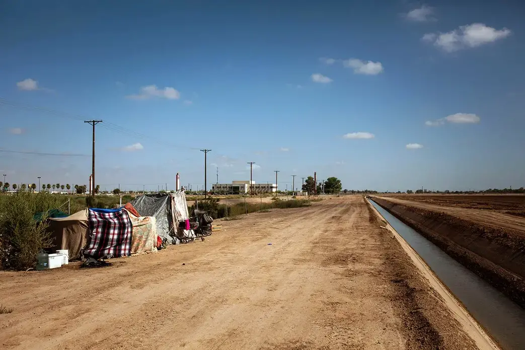A homeless encampment near a canal in El Centro, Calif., as seen on July 24, 2020. As support services have dwindled amid the COVID-19 pandemic, some homeless people in Imperial County have resorted to bathing in irrigation canals. Homelessness looks different in different parts of the U.S., especially in rural agricultural regions such as Imperial County. Image by Anna Maria Barry-Jester/KHN. United States, 2020.