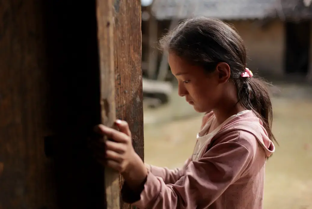 Twelve-year-old Wang Bing stands by the door of her family's farmhouse in Liangshan prefecture, Sichuan province. Image courtesy Max Duncan. China, 2016 Twelve-year-old Wang Bing stands by the door of her family's farmhouse in Liangshan prefecture, Sichuan province. Image courtesy Max Duncan. China, 2016