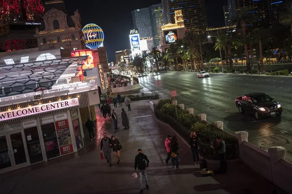 People walk along the Las Vegas Strip, Monday, Nov. 9, 2020. Things have gotten better in Las Vegas since casinos were allowed to reopen in June, following the springtime shutdowns to avoid the spread of the coronavirus. But the number of visitors is still just half of what it was a year ago. Image by Wong Maye-E / AP Photo. United States, 2020.