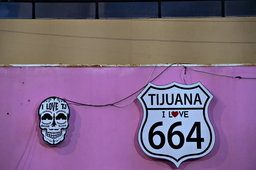 Signs advertise a tourist shop selling Tijuana-themed T-shirts, hats and souvenirs in Playas de Tijuana on Nov. 29. Image by Amanda Cowan. Mexico, 2019.