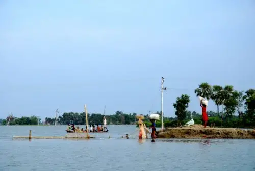 People fording water on foot in order to bring food back to their marooned village. Media file: 1060.jpg