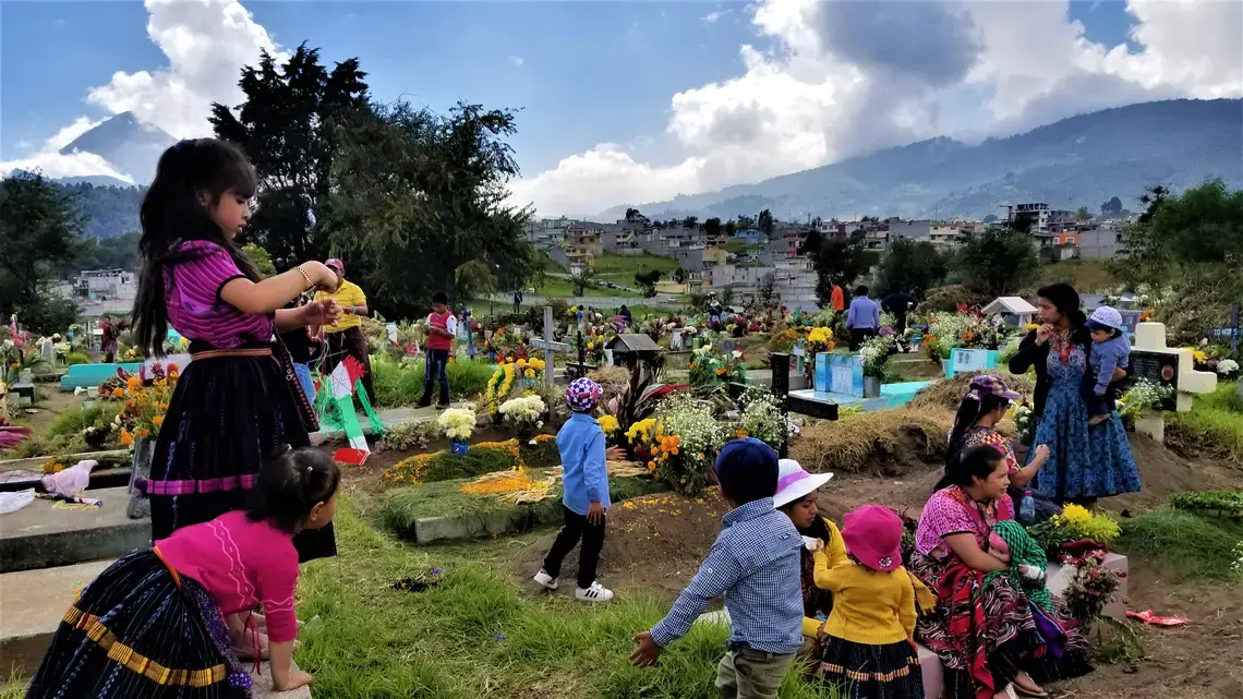 Cemeteries throughout Latin America, such as this one in Quetzaltenango, Guatemala, come to life when families decorate the graves of their loved ones with candles, fresh cut grass and flowers. For two days they pray, eat and remember their ancestors in honor of Day of the Dead. Image by Kristian Hernandez. Guatemala, 2018. Cemeteries throughout Latin America, such as this one in Quetzaltenango, Guatemala, come to life when families decorate the graves of their loved ones with candles, fresh cut grass and flowers. For two days they pray, eat and remember their ancestors in honor of Day of the Dead. Image by Kristian Hernandez. Guatemala, 2018.