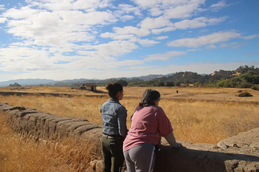 Allison Herrera and Mary Bishop, both Salinan Indians, look out at the Indian Cemetery at the San Antonio Mission in Lockwood, California.The cemetery was laid out in 1804 at the height of the mission building period in California. Missions were built by California Indians through force. The total number of California Indians laid out in this cemetery is unknown, although Mary said it was in the thousands. Image by Isaac Kestenbaum. California, 2017. Allison Herrera and Mary Bishop, both Salinan Indians, look out at the Indian Cemetery at the San Antonio Mission in Lockwood, California.
The cemetery was laid out in 1804 at the height of the mission building period in California. Missions were built by California Indians through force. The total number of California Indians laid out in this cemetery is unknown, although Mary said it was in the thousands. Image by Isaac Kestenbaum. California, 2017.