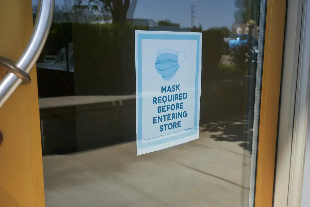 Mandatory mask policy signage at the entrance to a retail store in Oregon during the coronavirus pandemic. Image by Tada Images / Shutterstock. United States, 2020. Mandatory mask policy signage at the entrance to a retail store in Oregon during the coronavirus pandemic. Image by Tada Images / Shutterstock. United States, 2020.