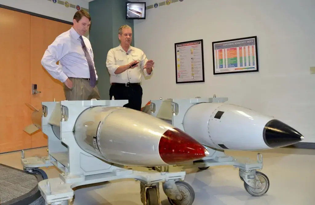 Sandia’s Senior Manager for the B61-12 Brad Boswell, left, with Jamie McIntyre, Al Jazeera America’s national security correspondent on special assignment for the PBS NewsHour. The mock-ups of the old B61-4 nuclear bomb, left, and the refurbished B61-12 bomb, right, look similar. The first production model of the B61-12 is scheduled to be fielded in 2020. It will be a “modernized version of the old bomb, where we are meeting the military requirements while looking for opportunities to improve the safety and the security of the weapon,” Boswell told McIntyre. One improvement is swapping out old-fashioned parts such as vacuum tubes, located in the bomb’s radar system, for modern electronics. Image by Dan Sagalyn. United States, 2015. Media file: nuke6-1024x667.jpg