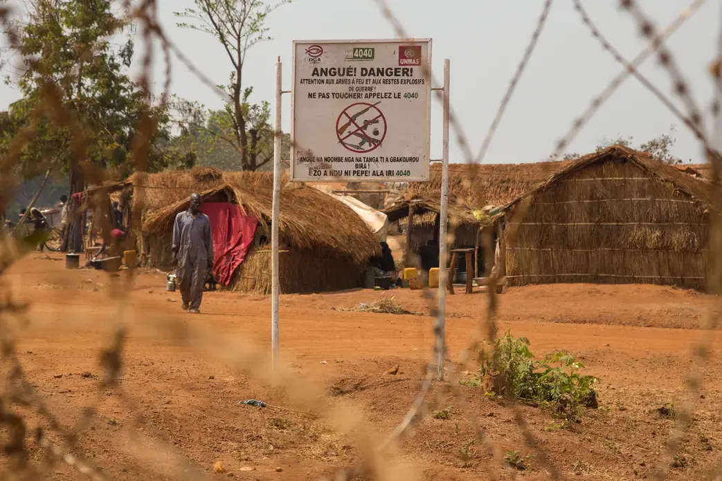 A sign at the entrance to the camp in Bria warns against bringing in weapons. Image by Jack Losh. Central African Republic, 2018. A sign at the entrance to the camp in Bria warns against bringing in weapons. Image by Jack Losh. Central African Republic, 2018.